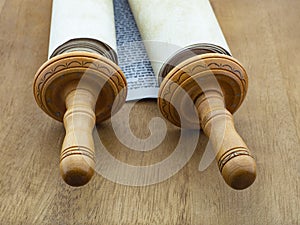 The Torah scroll from papyrus and wood on a wooden table of brown color.