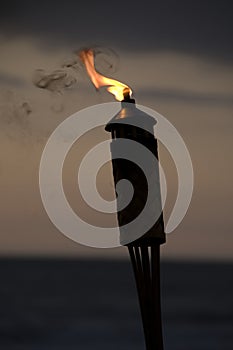 Torch on the beach at sunset.