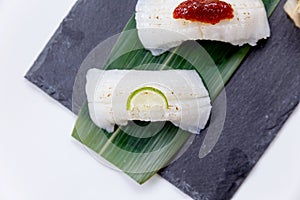 Torched Engawa Sushi Topping with Lime, Chilli Jam and Minced Daikon Served with Wasabi and Prickled Ginger.