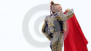 Torero in blue and gold suit or typical Spanish bullfighter isolated over white studio background. Close up, slow motion