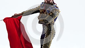 Torero in blue and gold suit or typical Spanish bullfighter isolated over white studio background. Close up, slow motion