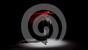 Torero in blue and gold suit or typical spanish bullfighter isolated spotlight on a black background. Close up, slow