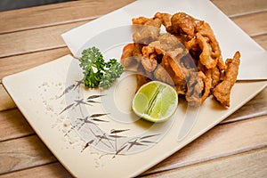 Tori kawa no karaage - japanese style deep fried chicken skin with salt and lime on wooden background , stock photo