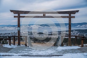 The torii gate with the panorama over the snow-covered hills close to Ulan-Ude.