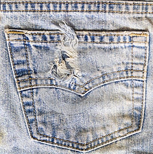 Torn blue jeans back pocket