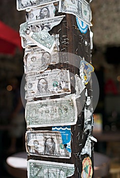 Torn and Damaged Dollar Bills Stapled to a Wooden Post