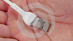 Torn damaged USB cable in the palm of hand