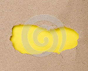Torn edges of brown paper on a yellow background, space for writing