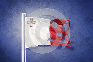 Torn flag of Malta flying against grunge background