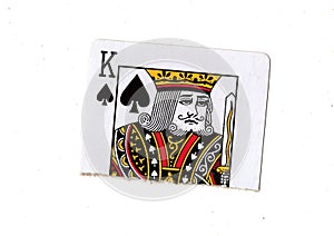 A torn half of a king of spades playing card.