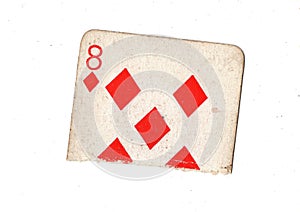 A torn half of a vintage eight of diamonds playing card.