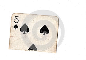 A torn half of a vintage five of spades playing card.