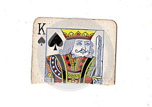 A torn half of a vintage king of spades playing card.