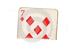 A torn half of a vintage seven of diamonds playing card.