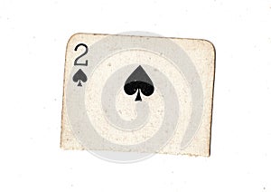 A torn half of a vintage two of spades playing card.