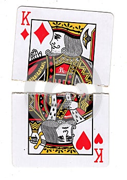 Torn halves of a king of diamonds and king of hearts playing cards.
