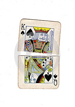 Torn halves of vintage playing cards showing a queen and king of spades.