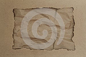 Torn hole of cardboard paper with space on Rumpled craft paper, background photo
