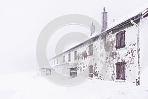 Torn house covered in snow - horizontal