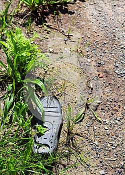 torn off rubber sole of a shoe in the meadow at the roadside