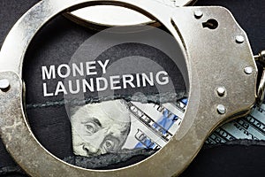 Torn paper, handcuffs and money. Money laundering concept.