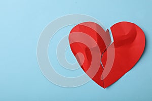 Torn paper heart on blue background, top view with space for text. Relationship problems concept