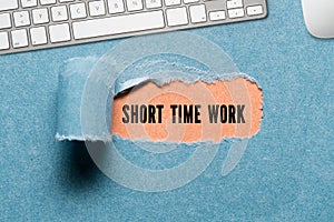 Torn paper revealing the text SHORT TIME WORK