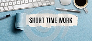 Torn paper revealing the text SHORT TIME WORK