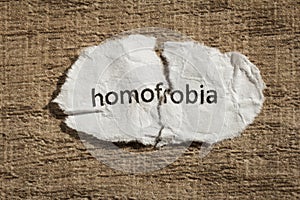 Torn paper written homofobia, portuguese and spanish word for ho photo