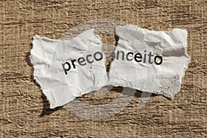 Torn paper written preconceito, portuguese word for prejudice, o