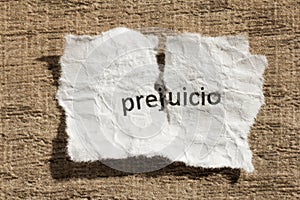 Torn paper written prejuicio, spanish word for prejudice, over w