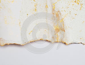 Torn piece of edge paper on white background. Gold and bronze color marble texture