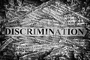 Torn pieces of paper with the word Discrimination