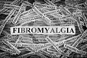 Torn pieces of paper with the word Fibromyalgia