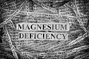 Torn pieces of paper with words Magnesium Deficiency