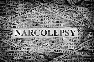 Torn pieces of paper with the words Narcolepsy