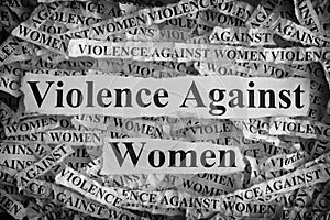 Torn pieces of paper with the words Violence Against Women