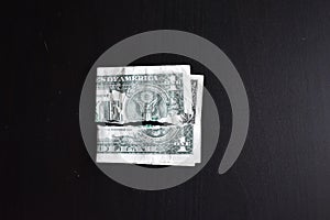 Torn ripped devalued one dollar bank note on a black background. close-up of bad money. The collapse of the dollar. Devaluation.