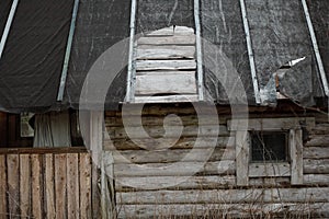 Torn ruberoid roofing material on the roof of the house