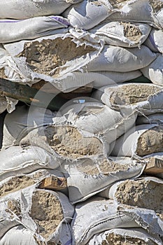 Torn sandbags placed around historical monuments and roadblocks during martial law in Ukraine. War in Ukraine, vertical photo