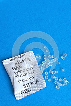 Torn silica gel bag with spilled beads.