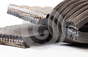 Torn timing belt and generator rivulet belt on a white background. Broken belts in the car, industry, close-up