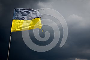 Torn Ukrainian flag on the background of a stormy