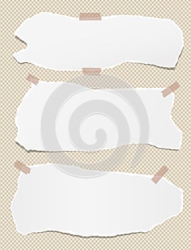 Torn white note, notebook paper strips stuck with sticky tape on squared brown background.