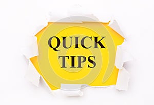 Torn white paper lies on a bright yellow background with the text QUICK TIPS photo