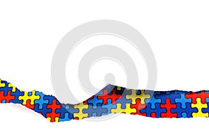 Torn white paper on multicolored puzzle background. Cocept for autism awareness day. Break barriers together for autism.