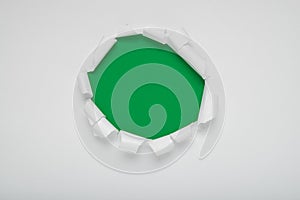 Torn white paper revealing a green background.