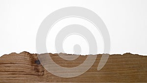 Torn white paper to reveal brown wood texture or background