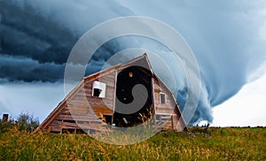 Tornado forming behind old barn