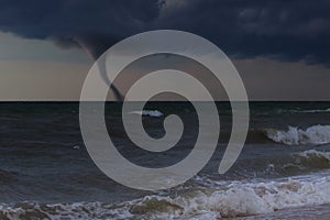A tornado taring across a deserted beach on ocean